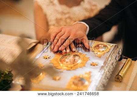 Groom And Bride Put Their Handrs On The Bible.