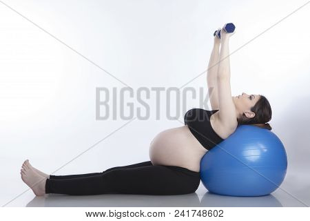 Pregnant Woman Is Doing Exercises With Gymnastic Ball On White Background