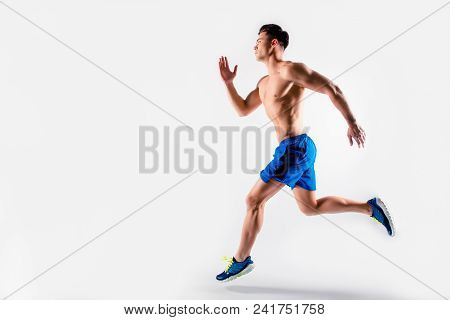 Ready, Steady, Go! Handsome Muscular Strong Determined Guy Dressed In Blue Shorts And Sneakers Is Ru