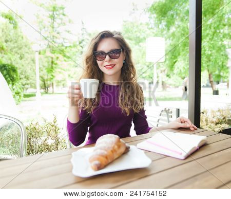 Beautiful Attractive Young Blonde Woman With Curly Hair Drinking Cappuccino And Eating Croissant In 