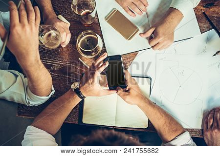 The Hands Of Young People Working And Relaxing In Pub. Team Job. Photo Businessmans Working With New
