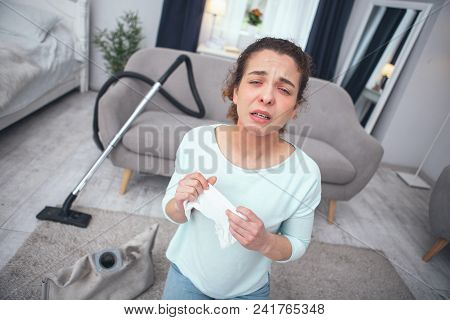 Sneezing Hard. Young Woman Looking Desperately Sick While Inhaling Dust Coming Out Of Dust Container