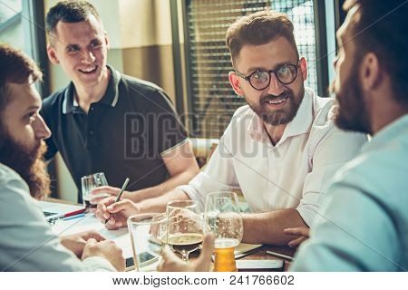 Young Cheerful People Smile And Gesture While Relaxing In Pub. Team Job. Photo Young And Mature Busi