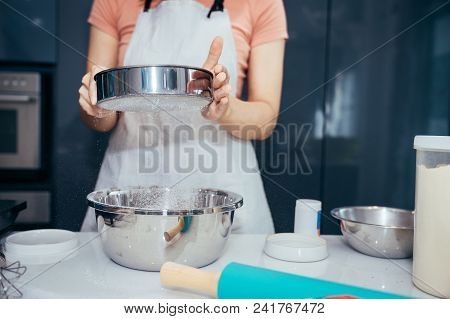 A Woman Sifting Flour Into A Stainless Bowl. Girl Is Sifting Flour To Making The Bakery In Her Kitch