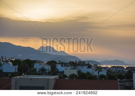 Dawn In Summer Over The City In The Mountains With Hanging Clouds On The Horizon At Sea. Turkey, Ala