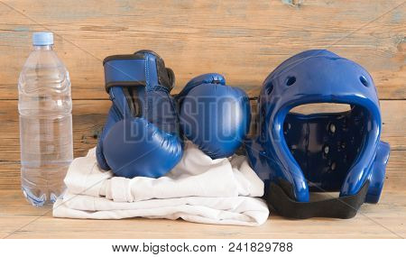 set Taekwondo equipment on a wooden background stock photos. Sports, martial arts. Protective equipment for fight in full contact