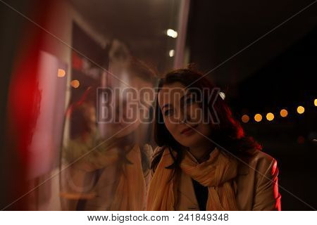 Girl Brunette Near In The Shopwindow On The Night City Street In A Cold Time