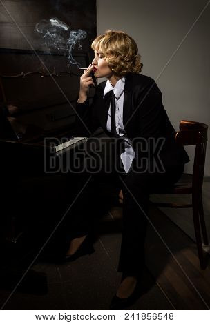 Beautiful Woman In A Business Suit Playing The Piano.