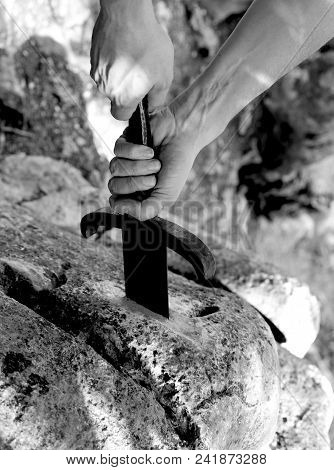 Hand Of Kinight And The Magical Excalibur Sword In The Stone With Black And White Effect
