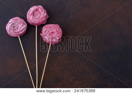 Sweet Meringues Cookies On Stick On Dark Background With Copy Space