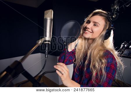 Music Is All Around! Young Cheerful Pretty Smiling Blonde Woman Recording A Song In A Professional S