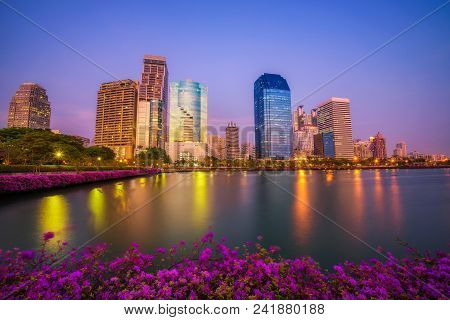 Lake Ratchada Situated In The Benjakitti Park With Beautiful Flowers In The Foreground And Modern Hi