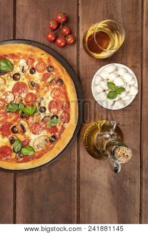 Overhead Photo Of Pepperoni Pizza With Glass Of White Wine, Olive Oil, Cherry Tomatoes And Mozzarell