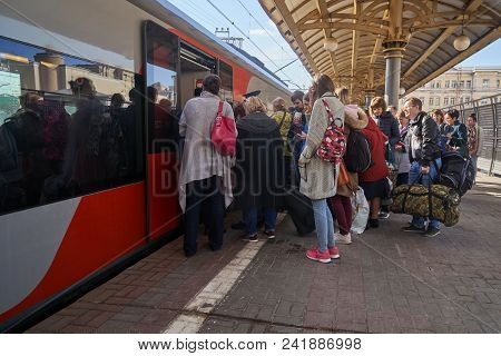 Moscow, Russia - April 28, 2018. People Taking A Modern Russian Train Called Lastochka On A Platform