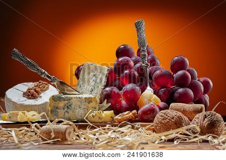 Different Types Of Cheese, Vintage Knife And Fork For Cheese And Grapes. Dark Background. Place For 