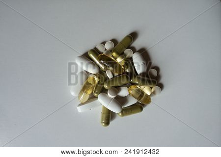Green Moringa And Yellow Fish Oil Capsules, White Calcium Caplets And Vitamin K2 Tablets From Above