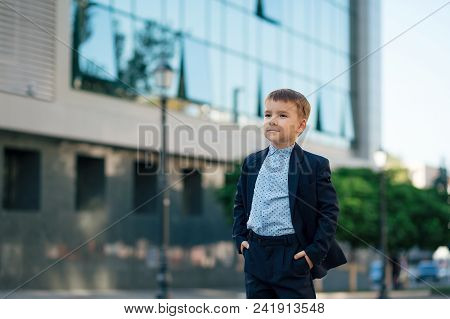 Concept Future Businessman. Serious Boy In Classic Modern Dark Blue Business Costume And Baby Blue S