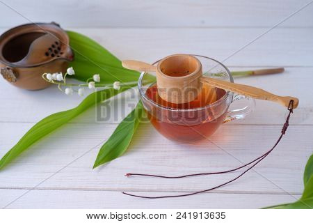 Old Chinese Tea Shen Puer In The Form Of A Nest, Brewed Tea In A Glass Cup And A Flower Of Silver Li