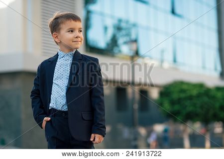 Concept Future Businessman. Portrait, Boy In Classic Dark Blue Business Suit And Baby Blue Shirt Loo