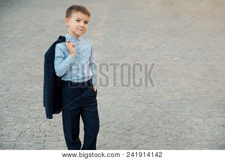 Portrait Elegant Little Man In Fashionable Navy Blue Shirt Holding Dark Blue Jacket On His Back Smil