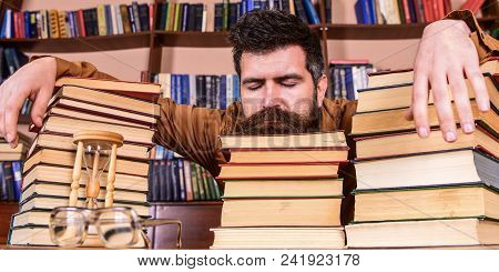 Man On Sleeping Face Lay Between Piles Of Books, Fall Asleep While Studying In Library, Bookshelves 