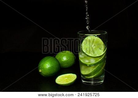 Summer Refreshing And Beverages Concept. Stream Pours Into A Glass Of Cold Drink With Ice And Fresh 