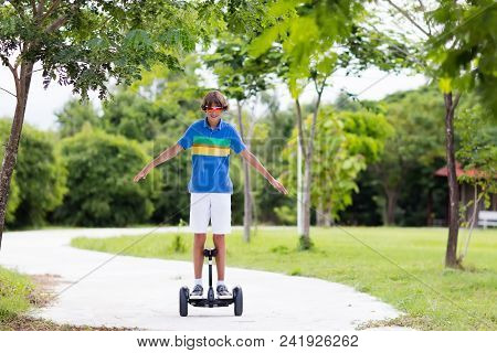 Child On Hover Board. Kids Riding Scooter In Summer Park. Balance Board For Children. Electric Self 