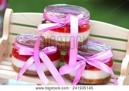 Сheesecake With Berry Jelly In Small Jars With Ribbons.