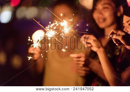 Blurred Of Sparklers With Group Of Friends Having Fun For Celebration And Hand Holding A Burn Sparkl