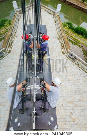 Industrial Climbers Are Applying Silicone On Joints Between Windows