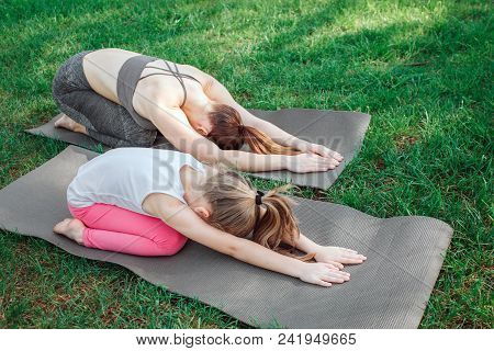 Mom And Aughter Are Relaxing. Also They Have Curved Their Bodies And Stretching In That Way. Girls A