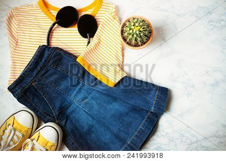Outfit Of Teen Or Woman Clothes And Accessories On Marble Background. Denim Skirt, T-shirt With Yell
