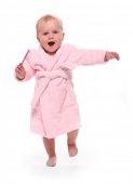 Happy child dressed in bath robe with hair brush.