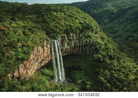 Waterfall Falling From A Cliff Covered By Forest