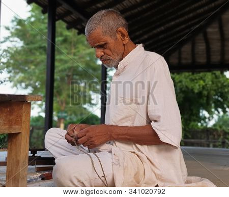 November 30, Maharashtra India, - An Elderly Man In White Dress Sweing Cloth At Gandhi Ashram At Sev