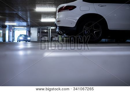 Underground parking. Cars parked in a garage with no people. Many cars in parking garage interior. Underground parking with cars (color toned image)