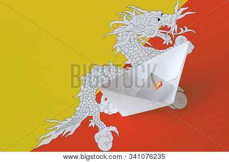 Bhutan Flag Depicted On Paper Origami Ship Closeup. Handmade Arts Concept