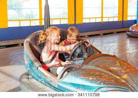 Children Ride On Electric Cars In An Amusement Park.