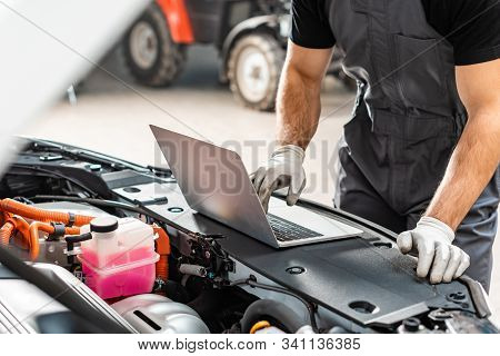 Cropped View Of Mechanic Using Laptop Near Car Engine Compartment