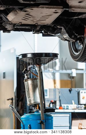 Pneumatic Waste Oil Extractor Under Raised Car In Workshop