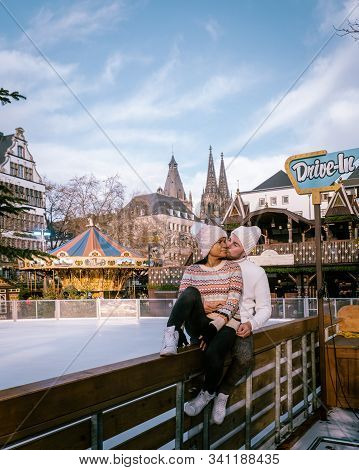 Young Couple Visit The Christmas Market In Cologne Germany During A City Trip, Men And Woman At Chri