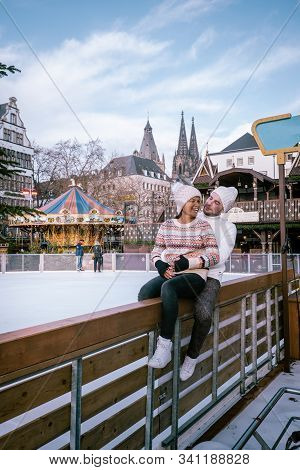 Young Couple Visit The Christmas Market In Cologne Germany During A City Trip, Men And Woman At Chri