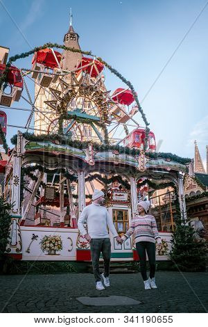 Young Couple Visit The Christmas Market In Cologne Germany During A City Trip, Men And Woman At Chri