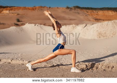 Young Woman Stretching Legs And Warming Up At The Nature. Attractive Girl Stretching Before Fitness.