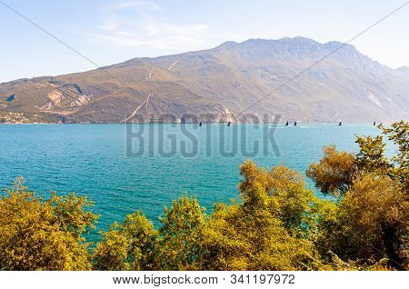 Garda Lake, Lombardy, Italy - September 12, 2019: High Black Sails Of Sailing Boats Moving Fast With