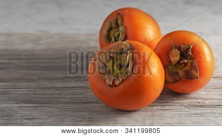 Delicious Fresh Persimmon Fruit On A Wooden Table. Close-up.