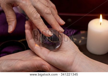 Woman Fortuneteller Puts A Ball Of Fate In Her Hand, A Magic Ball Of Predictions. The Concept Of Pre