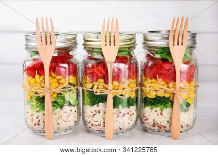 Glass Jars With Healthy Meal On White Wooden Table