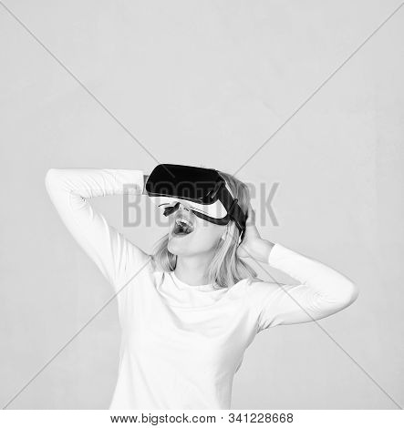 Amazed Young Woman Touching The Air During The Vr Experience. Portrait Of Young Woman Wearing Vr Gog