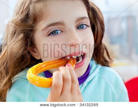 Occhi blu bambina mangiare krapfen fritti churros sorridente